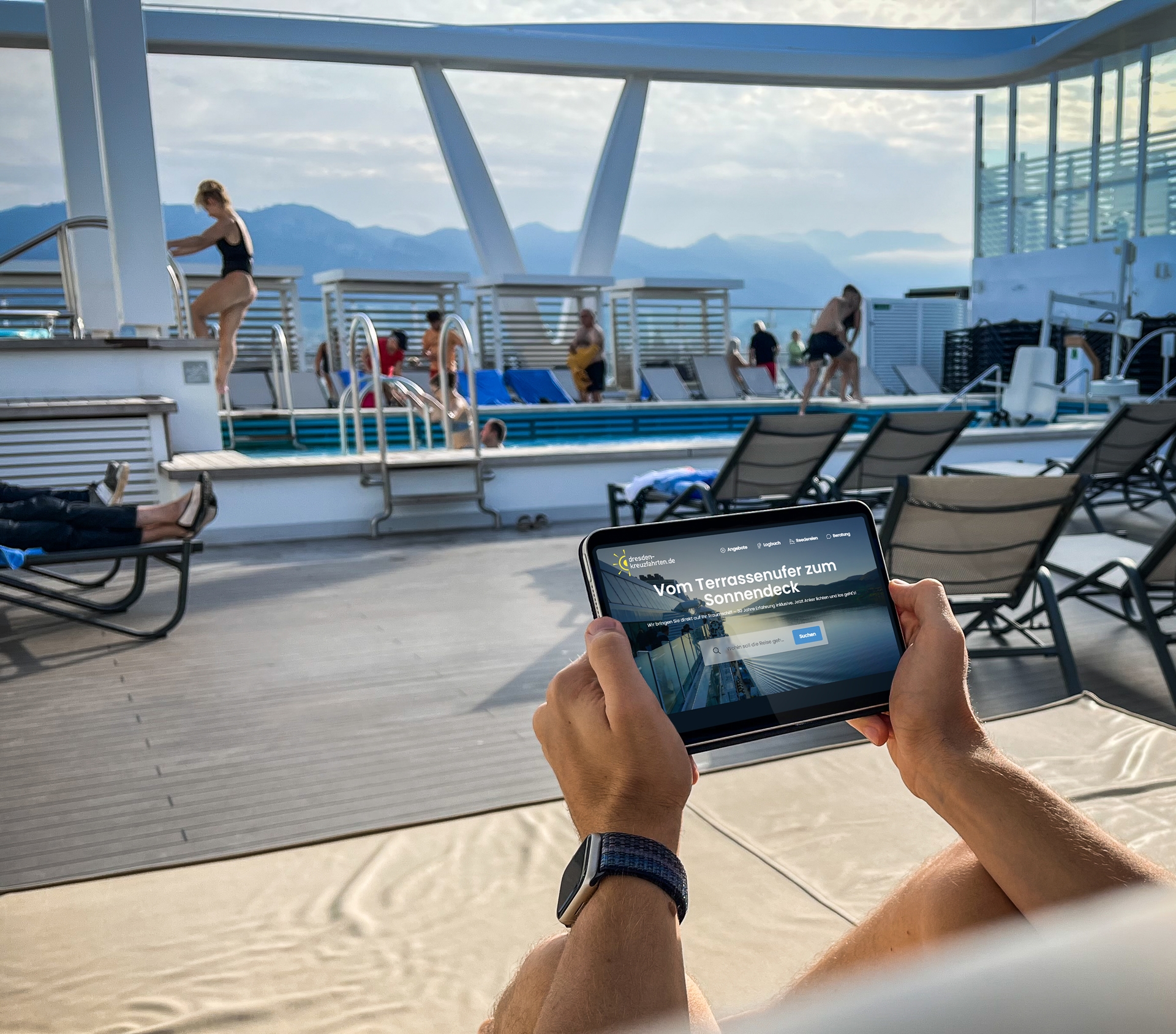 Foto einer Person auf dem Sonnendeck eines Kreuzfahrtschiffes, die ein Tablet mit der Webseite dresden-kreuzfahrten.de hält.